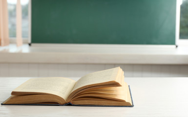 Women hands with book on blackboard background