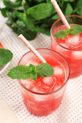 Cold watermelon drinks in glasses, on wooden table background