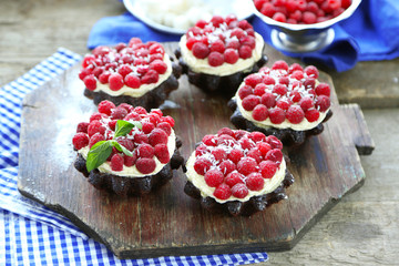 Sweet cakes with raspberries on wooden table background