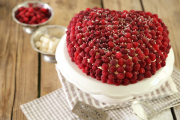 Sweet cakes with raspberries on light wooden background