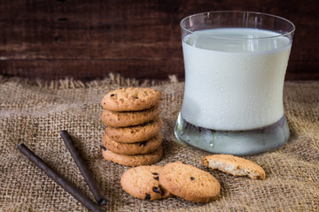 Cookies and a glass of milk on a wooden background