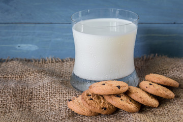Cookies and a glass of milk on a wooden background