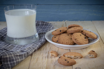 Cookies and a glass of milk on a wooden background