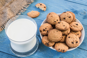 Close up cookies and glass of milk on wooden table