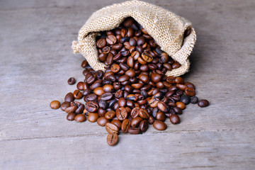 Coffee beans in sackcloth bag on wooden table