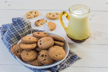 Close up cookies and glass of milk on wooden table