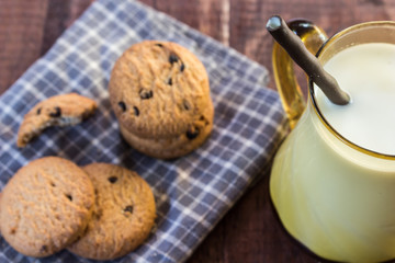 Close up cookies and glass of milk on wooden table