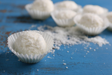 Coco sweets on color wooden background