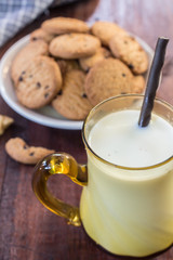 Close up cookies and glass of milk on wooden table