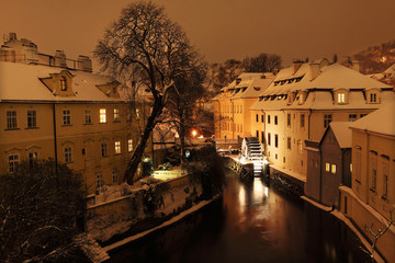Fototapeta na wymiar Night romantic snowy Prague Mill above Certovka, Czech republic