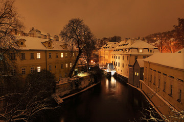 Night romantic snowy Prague Mill above Certovka, Czech republic