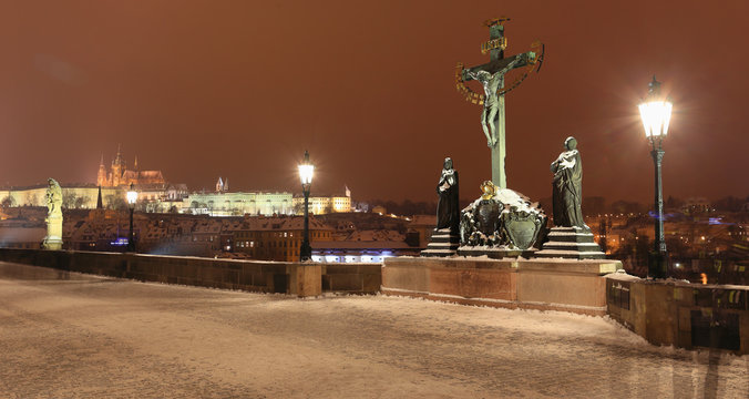 Night View on snowy Sculpture of Jesus from Charles Bridge, Czech Republic