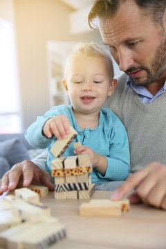 Daddy with 2-year-old boy playing with wooden blocks