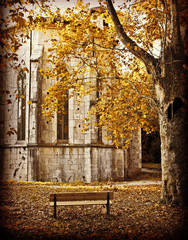 Autumnal view of old abbey with bench and red tree, retro effect added