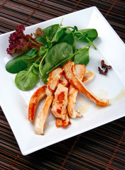 Grilled chicken breast with lettuce leaves and cloves