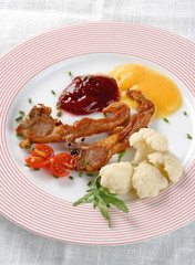 Fried lamb cutlets served with two types of jam and cauliflower