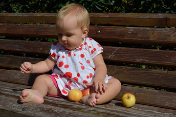 cute baby girl throwing the apples away