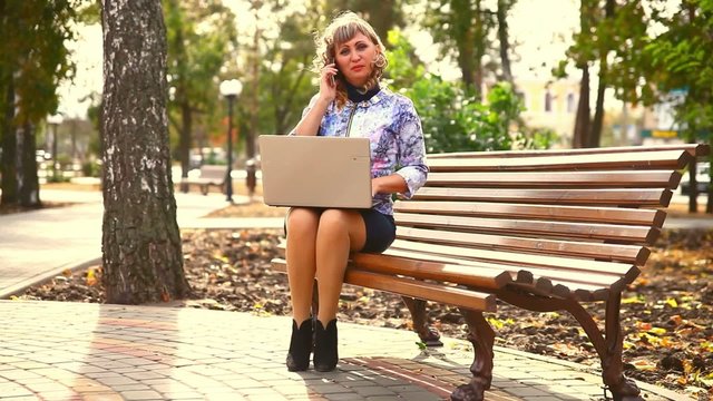 middle-aged woman full of fat sitting on park bench working wind