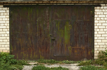 The iron gates of the old garage repogodoy damaged.