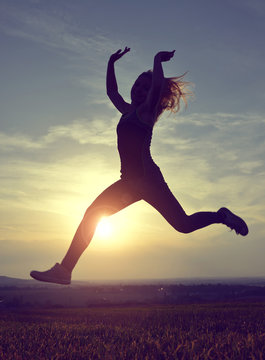 Young woman jumping at sunset