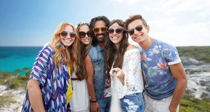 happy hippie friends with selfie stick on beach