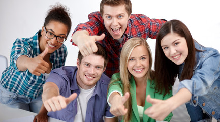 group of happy students showing thumbs up
