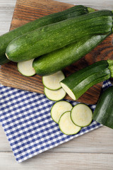 Fresh sliced zucchini on cutting board, on wooden background