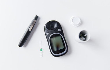 close up of glucometer and blood sugar test stripe