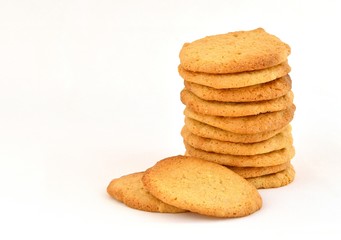 Neat stack of homemade peanut butter cookies with two resting in front of it. On a white background.