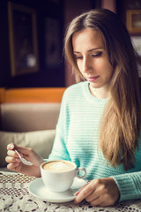 Young woman drinking coffee in a cafe