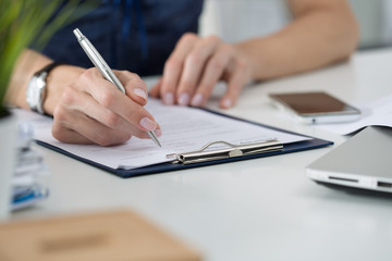 Woman writing something sitting at her office