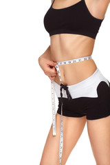 Young slim girl measuring waist tape. 