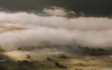 Mountain landscape with summer morning fog at sunrise