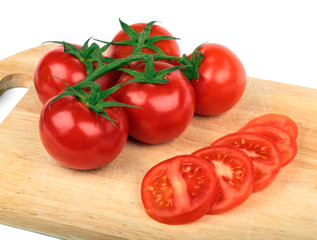 Fresh tomatoes and  tomatoes slices on a hardboard