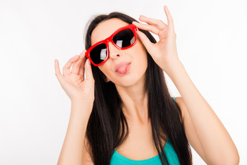Funny young asian woman with red glasses showing tongue