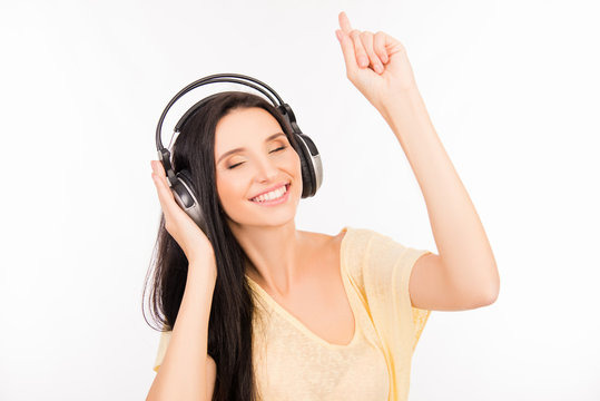 Cute girl listening to music on headphones and dancing