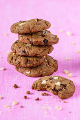 Schokoladen-Nuss-Cookies auf rosa Hintergrund