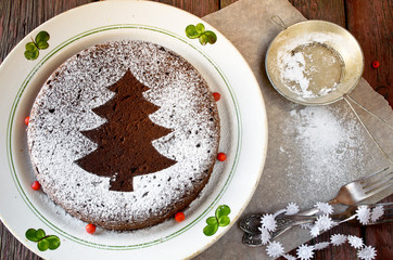 Fototapeta na wymiar Homemade chocolate Christmas cake sprinkled with sugar powder