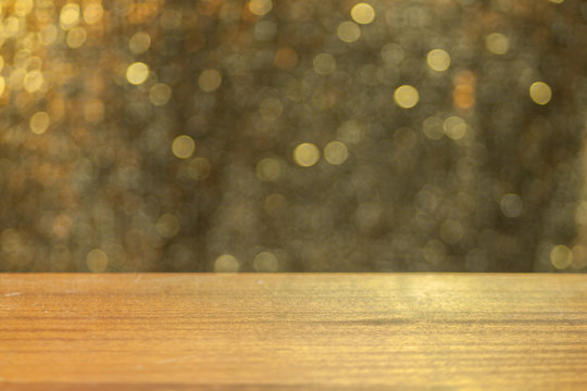 Fototapeta Empty wooden plank. Empty table with bokeh background. Product display montage. Vintage bokeh background. Gold retro bokeh. Fairy defocused backdrop. Celebration wallpaper.  