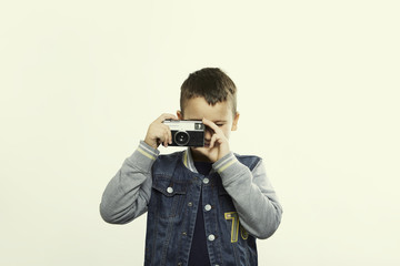 Kid with vintage camera against light yellow background