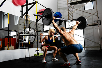 couple of weightlifters training together with barbells