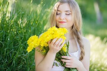 Closeup portrait of cute young girl with yellow flowers smiling outdoors 
