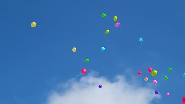 Balloons in the sky, a festive release of colorful balloons to the sky, blue sky, celebration and fun, gel balls, video background with balloons in the sky.