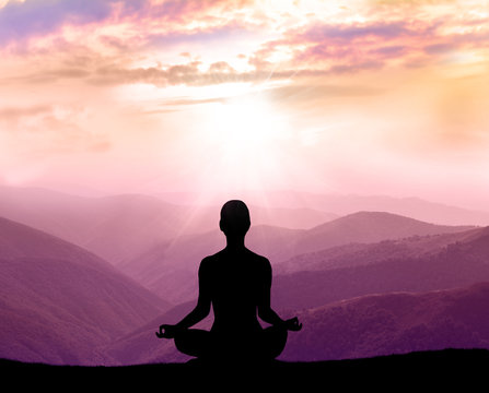 Yoga and meditation. Silhouette of man in the mountain