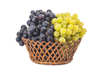 Ripe red and white grapes in woven basket isolated on a white