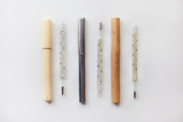 Vintage mercury thermometers on white background