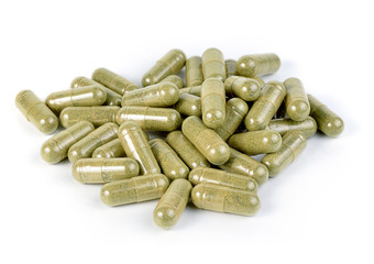 herb capsule with green herbal leaf isolated on white background