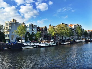 Häuser und Hausboot an Gracht in Amsterdam