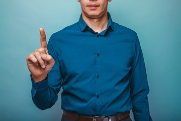 Fototapeta premium a man in a blue shirt raised his index finger on a gray backgrou