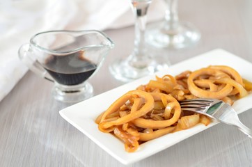 Fried squid rings with onion. Appetizer.